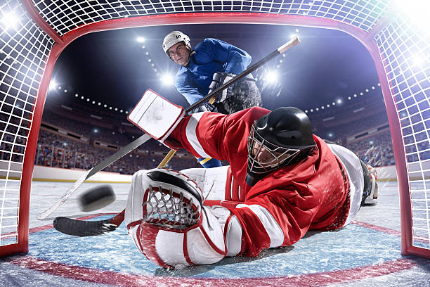 joueur de hockey sur glace de marquer - ice hockey hockey puck playing shooting at goal photos et images de collection