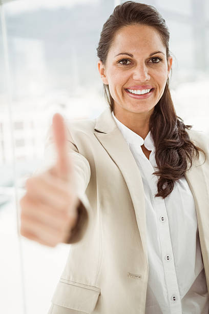 istock Businesswoman gesturing thumbs up in office 522260065
