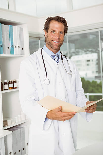 istock Confident smiling doctor with reports at medical office 522260641
