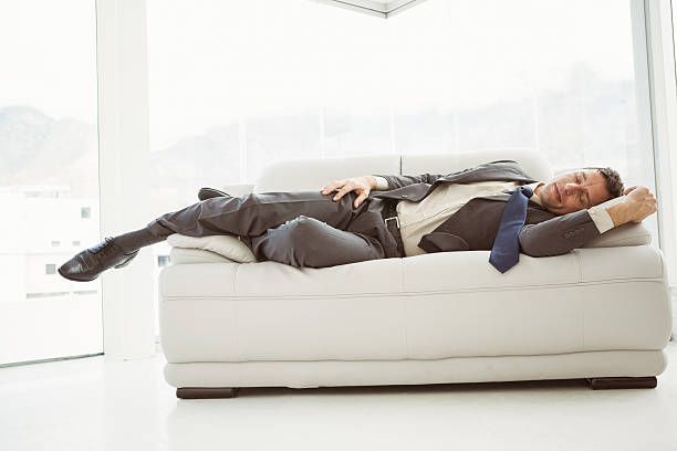 istock Businessman sleeping on couch in living room 522261495