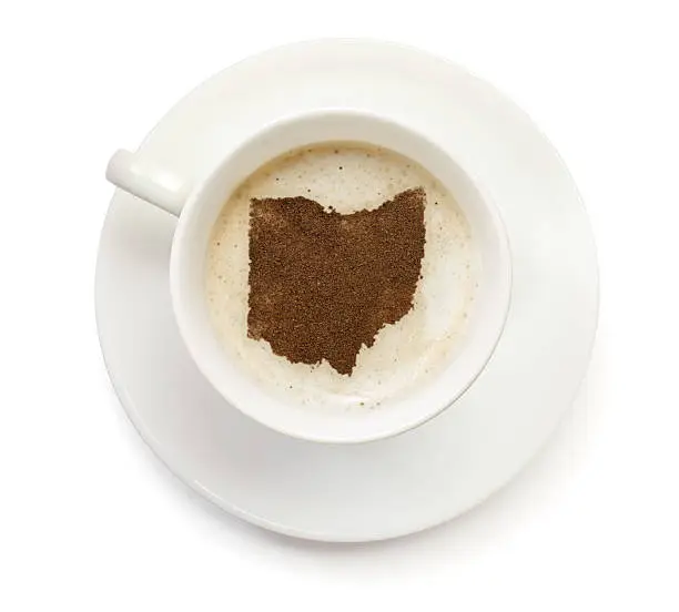 A top shot of a cup of coffee with froth and powder in the shape of Ohio (USA).(series)   How about having a break :)