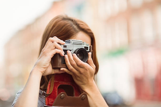 istock Pretty redhead taking a picture with retro camera 522276647
