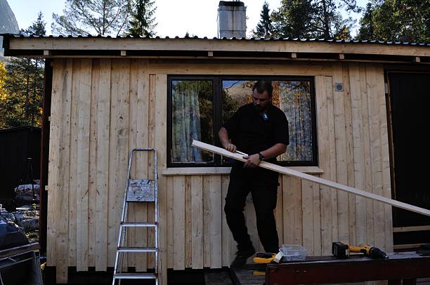 istock Replacing wood on wall of cabin in Norway 522276809