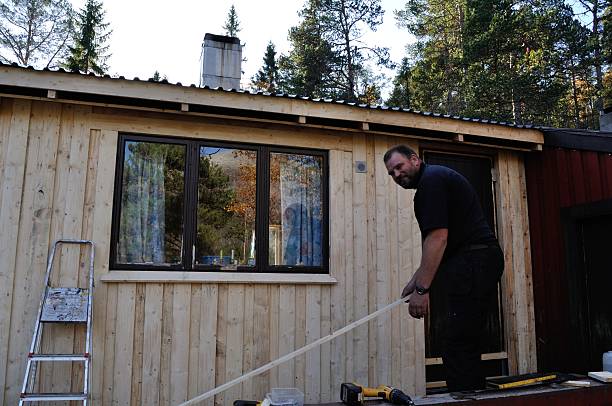 istock Replacing wood on wall of cabin in Norway 522276811