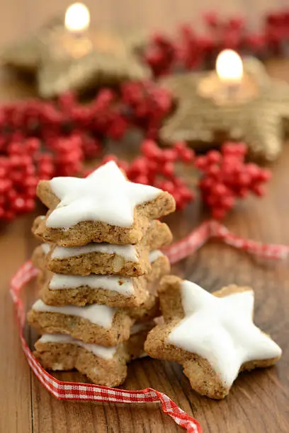 cinnamon cookies in star shape with christmas balls, candles and ribbon