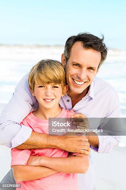 Man Embracing Son From Behind At Beach Stock Photo - Download Image Now - 10-11 Years, 30-39 Years, 35-39 Years