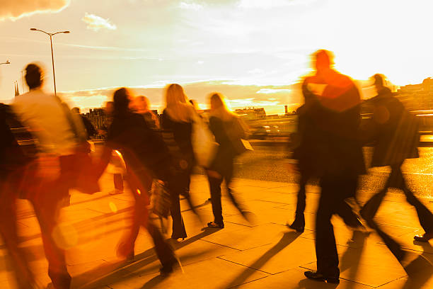 istock Large Group of Blurred Business People Rushing in Sunset Light 522294783