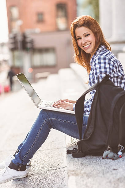 istock Woman using her laptop and smiling at camera 522295061