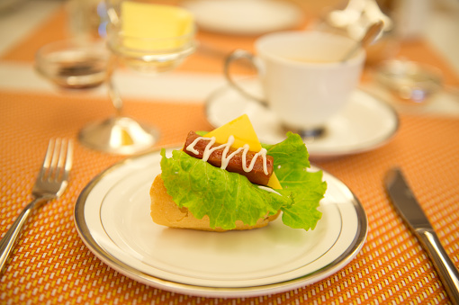 breakfast with hot dog and tableware.