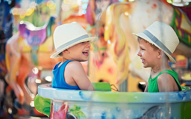 Little brothers having fun on carousel.