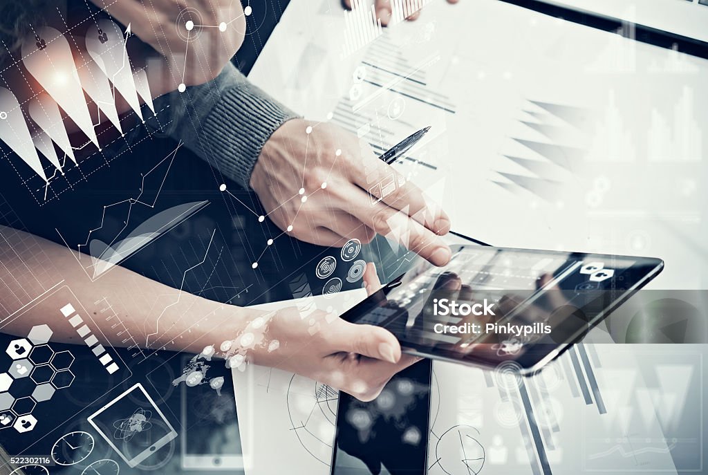 Photo female hands holding modern tablet and man touching screen Photo female hands holding modern tablet and man touching screen.Businessmans crew working new investment project  office.Using electronic devices.Graphics icons, stock exchanges interface.  Analyzing Stock Photo