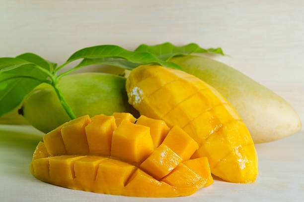 istock Ripe yellow mango with leaf on wooden background 522303076