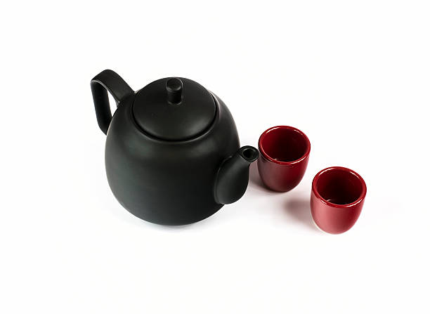 istock Black ceramic teapot and two red cups isolated on white 522303876