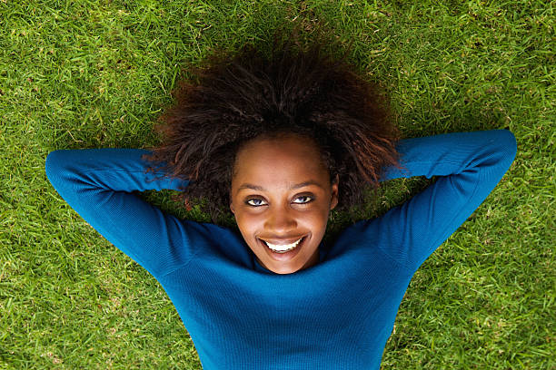 istock Smiling black woman lying on grass 522306888