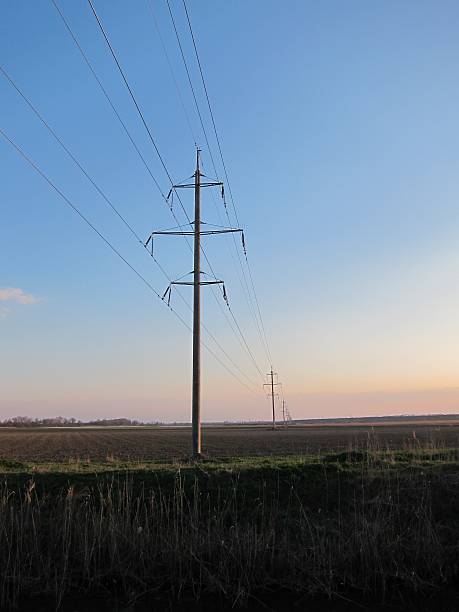 istock Transmission tower on a plowed field near the river 522306964
