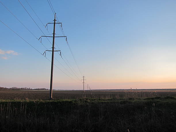 istock Transmission tower on a plowed field near the river 522306982