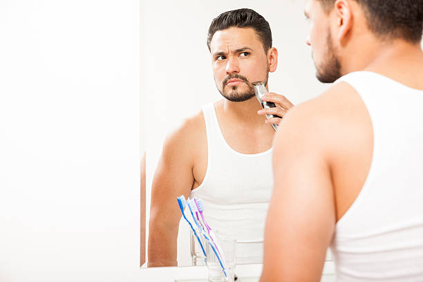 istock Young man trimming his beard in the bathroom 522308902