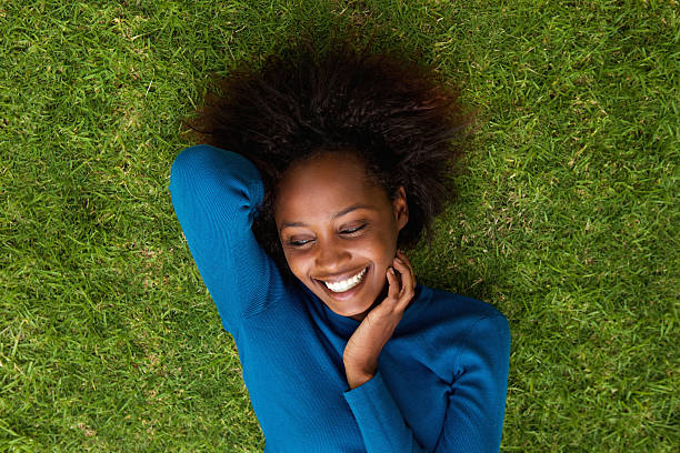 istock Smiling african woman lying on grass 522309168