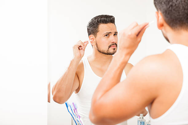 istock Handsome man cleaning his ears with a swab 522309642