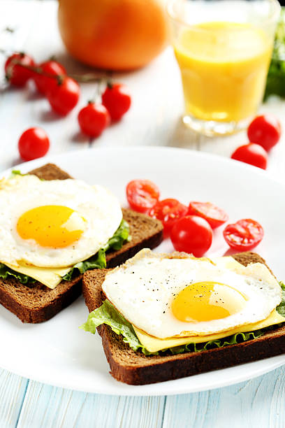 istock Fried eggs with toasts on plate on blue wooden table 522310180