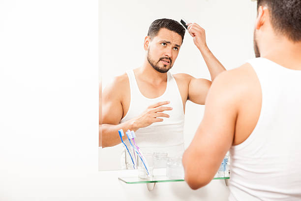 istock Good looking guy combing his hair 522310338