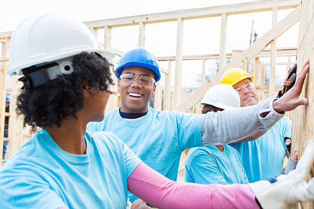 istock Volunteer hold up wall at construction site 522310854