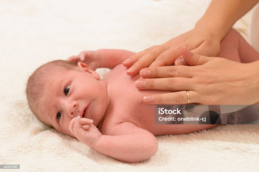 Newborn Baby getting oil massage Newborn Baby getting oil massage by his mother Moisturizer Stock Photo