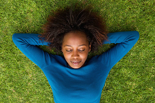istock Young african woman lying on grass sleeping 522311342