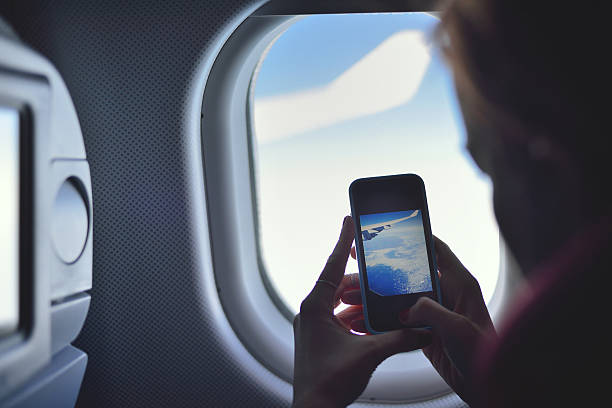 istock Young woman taking a picture on an airplane 522311516
