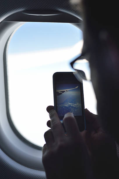 istock Young man taking a picture on an airplane 522311626