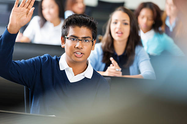 Male Student Eager to Answer a Question in Class Smart Indian student answering question in private high school teenage high school girl raising hand during class stock pictures, royalty-free photos & images