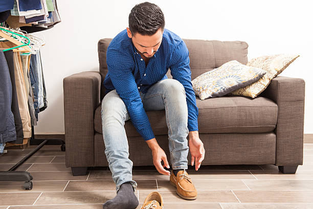 istock Young man putting shoes on in dressing room 522312032
