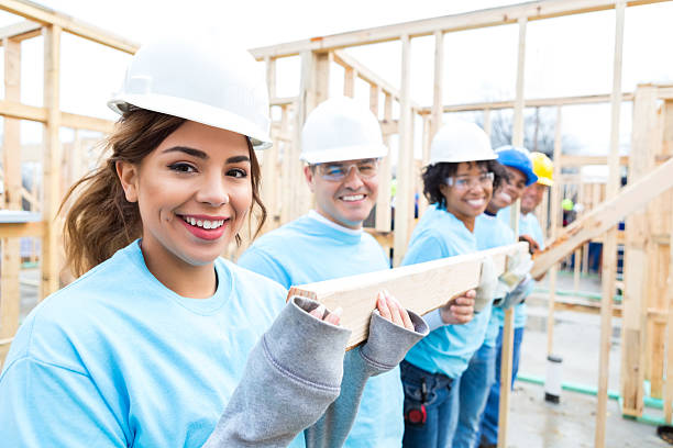 istock Friends carry board at charity home work site 522312486