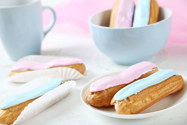 istock Eclairs with glaze on a white wooden table 522312494