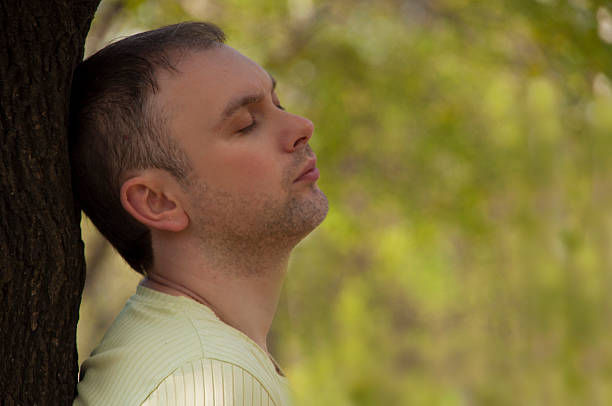 istock pensive man with closed near a tree 522313592