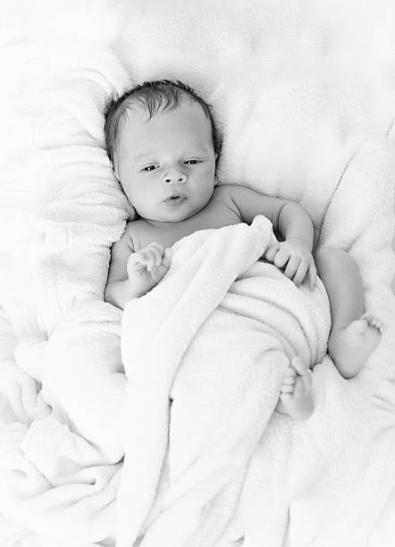 istock cute baby boy covered in blanket on bed 522313626