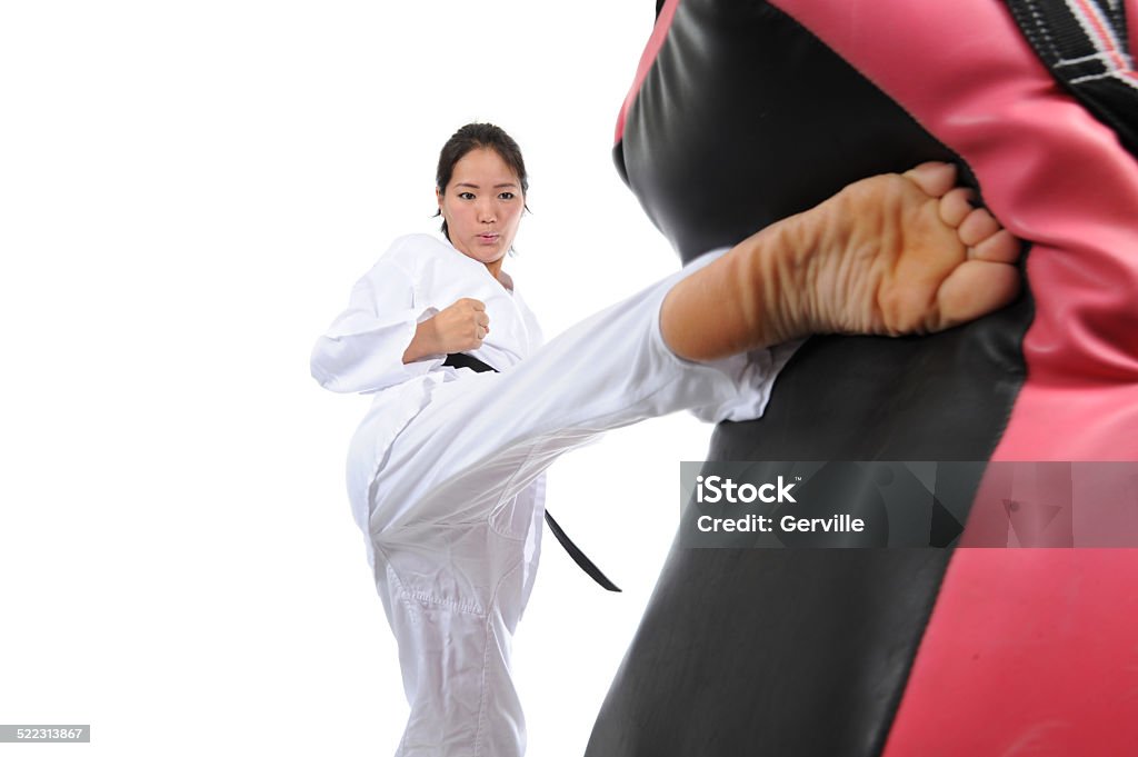 Right Foot Roundhouse Action Asian female kicking a padded focus shield with a powerful roundhouse. Barefoot Stock Photo