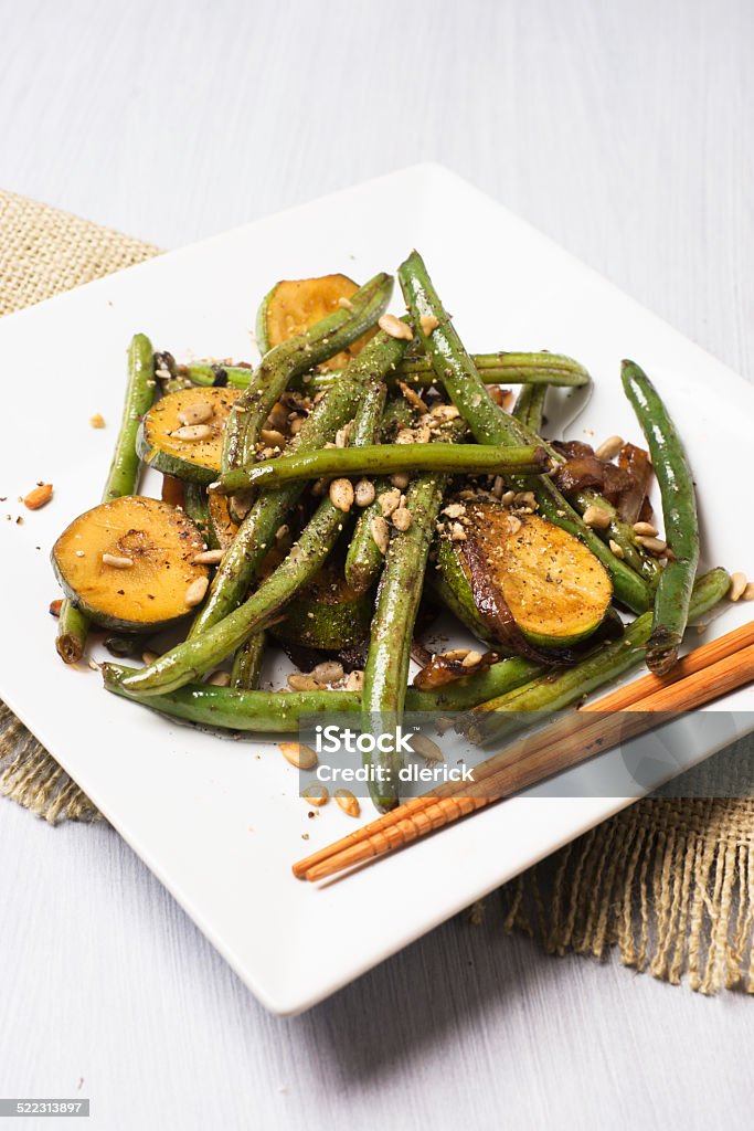 Asian Cuisine: Vegetable Stir Fry Sweet and sour Asian stir fry vegetable dish.  Ingredients: string beans, zucchini, onion, sunflower seed, coarse ground black pepper, balsamic vinegar, and olive oil.  Caramelized onions give a sweet taste which contrasts with a sour taste ofr the balsamic vinegar.  Shot with a Sony Alpha A99V 24 mega pixel camera and a 70mm macro lens. Close-up Stock Photo