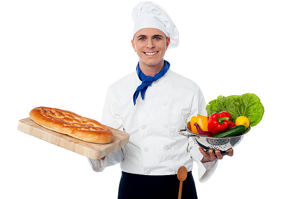istock Smiling chef holding bread and vegatables 522314867