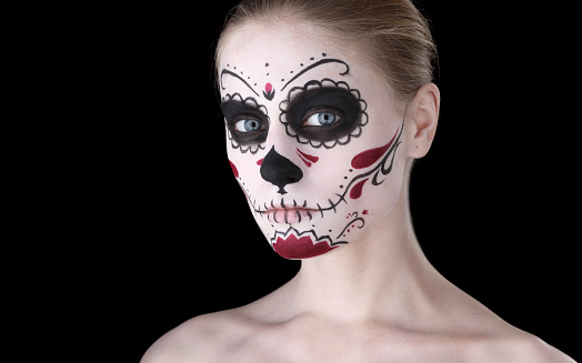 Woman with dia de los muertos makeup, black empty space