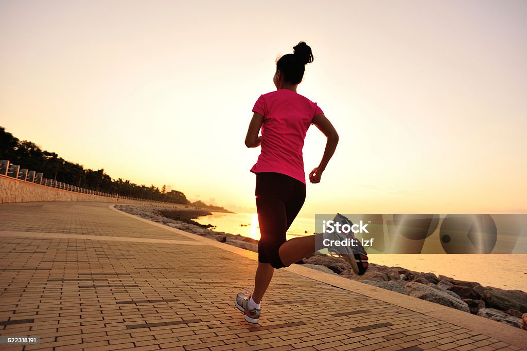 healthy lifestyle asian woman running at sunrise seaside Activity Stock Photo