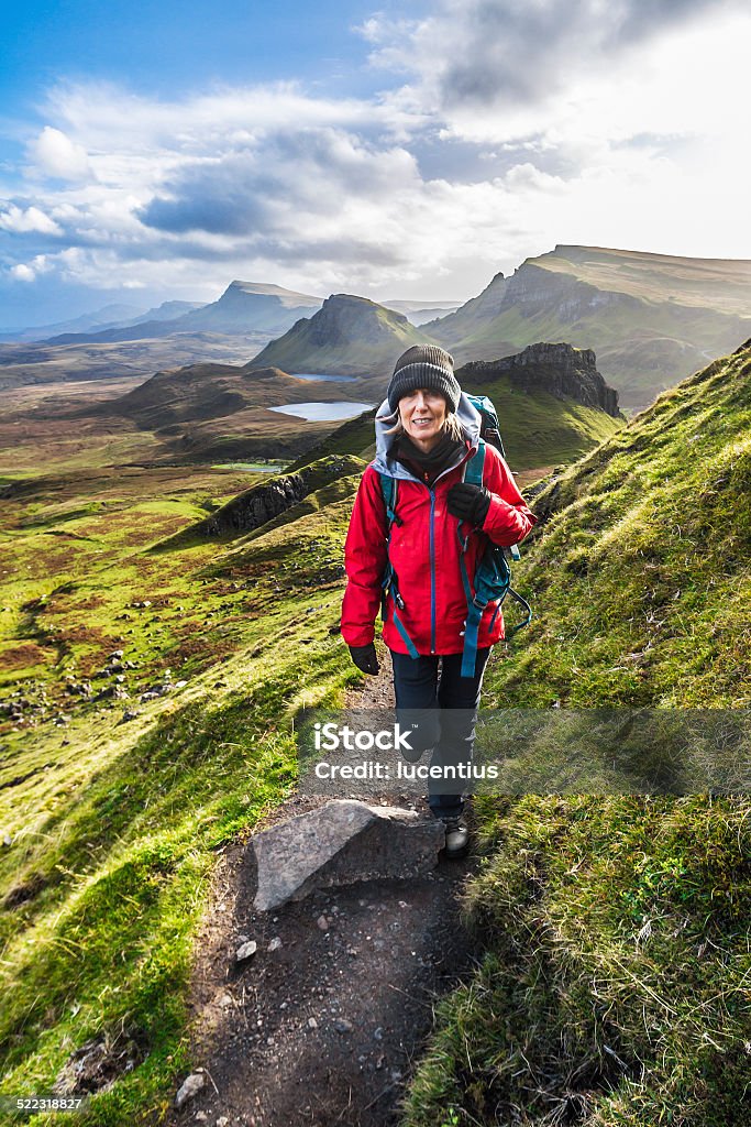 Woman on Quiraing Trail, Isle of Skye Scotland Adult woman walking on the trail to the Quiraing on the Isle of Skye in Scotland. AdobeRGB colorspace. Hiking Stock Photo