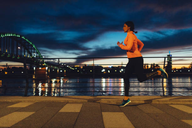 istock Young Woman Jogging At Night Near River. 522320360