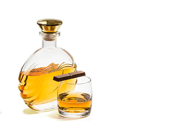 bottiglia e bicchiere di whisky con cioccolato su sfondo bianco - gin decanter whisky bottle foto e immagini stock