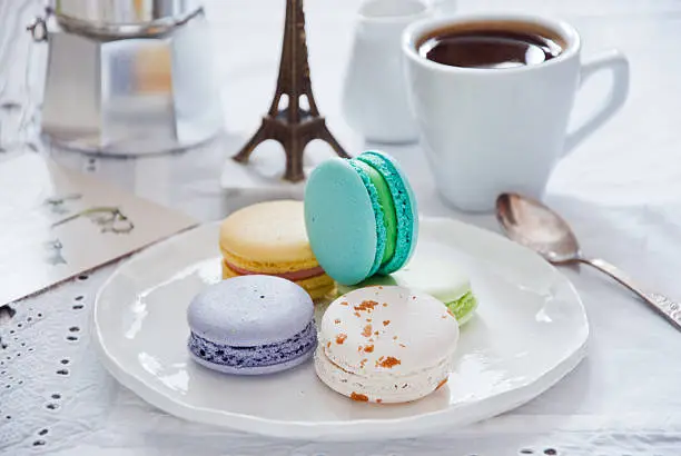 Breakfast with French colorful macarons and a coffee maker with coffee cup