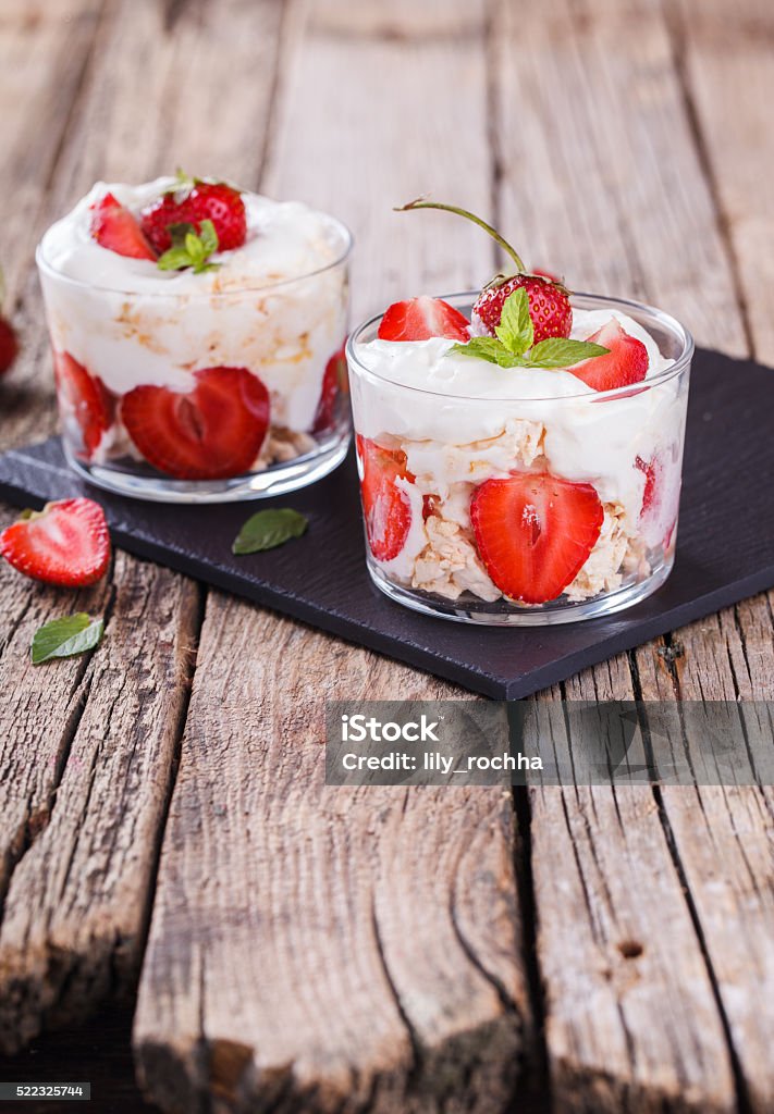 Eton Mess - Strawberries with whipped cream Eton Mess - Strawberries with whipped cream and meringue in a glass beaker. Classic British summer dessert.selective focus Cream - Dairy Product Stock Photo