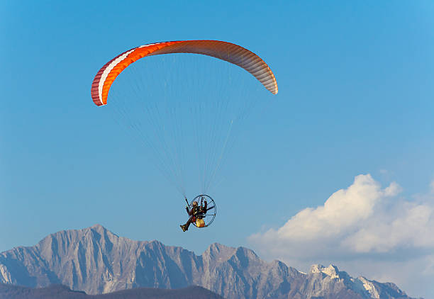 Man paragliding with Para-motor Flying with powered paraglider over Apuan Alps, Italy ultralight photos stock pictures, royalty-free photos & images