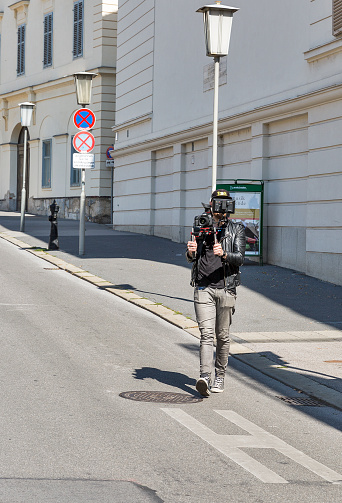 Graz, Austria - September 12, 2015: Unrecognized cameraman getting video on Freiheitsplatz.