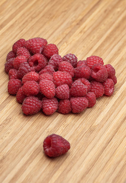 istock Heart from many raspberries on the wooden board 522329804