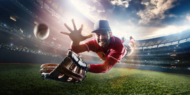 Outfielder Catching Baseball Outfielder baseball player about to catch ball during baseball game on outdoor baseball stadium under dramatic stormy skies. pro baseball player stock pictures, royalty-free photos & images